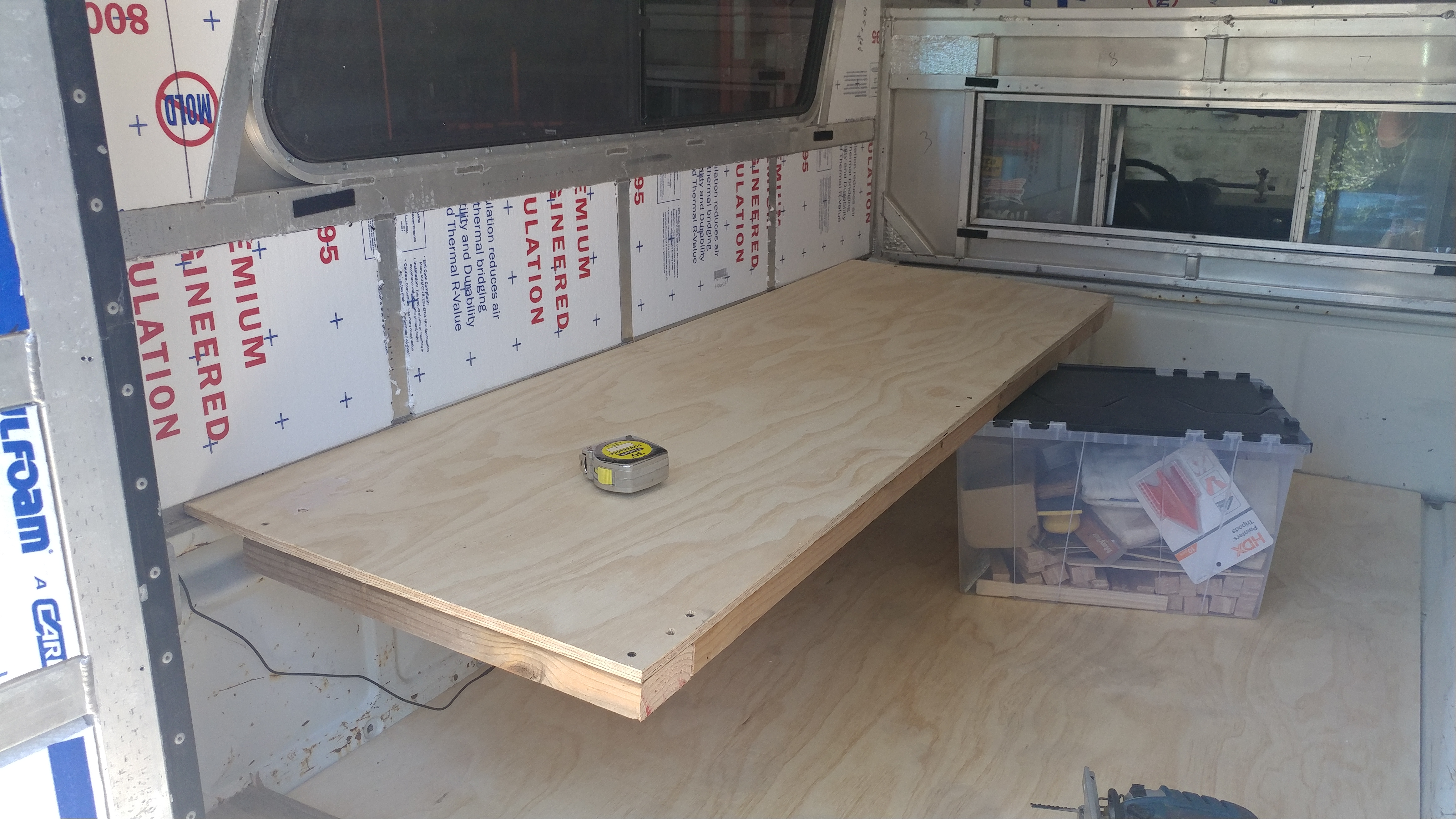 Truck bed with plywood floor and top of bedframe